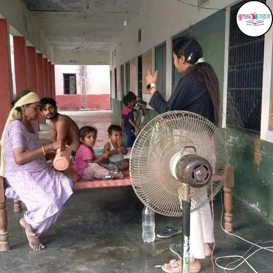 A Buland Udaan team member speaking with a family during a community support visit