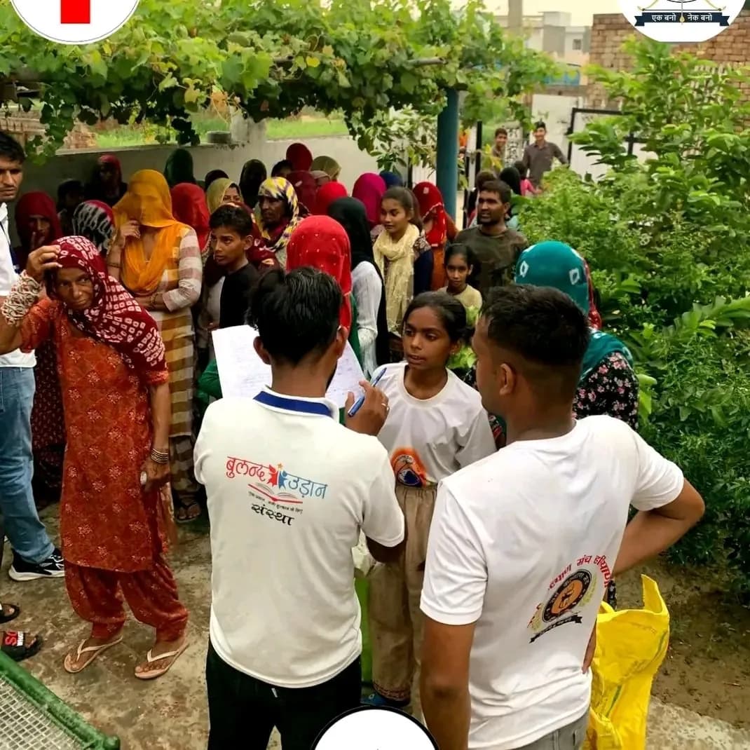 Buland Udaan volunteers in branded t-shirts recording details from families during a community visit